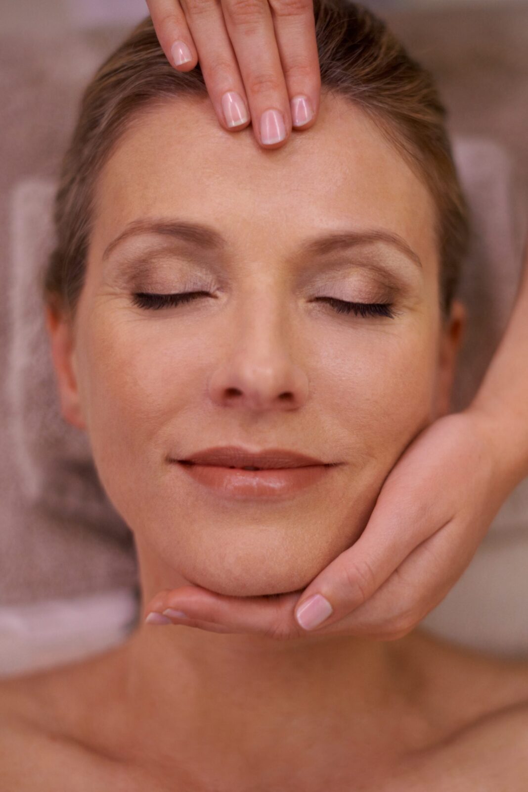 Cropped shot of a woman in a day spa getting a face massage.