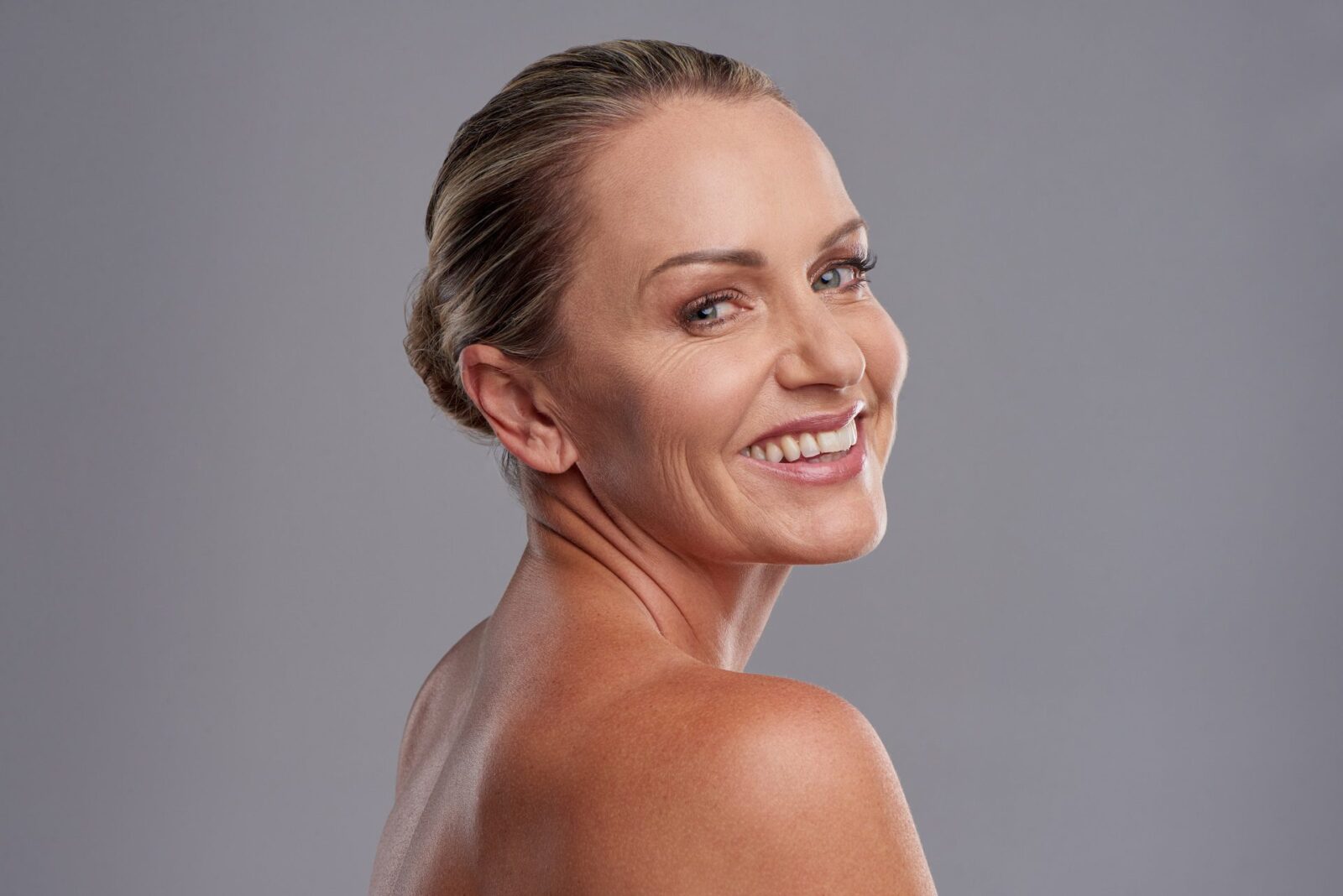 Studio portrait of an attractive mature woman posing against a grey background